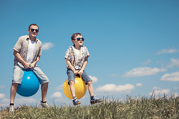 Image showing Father and son playing on the field at the day time.