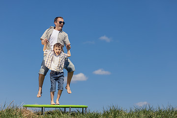 Image showing Father and son playing on the field at the day time.