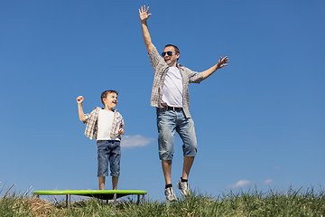 Image showing Father and son playing on the field at the day time.