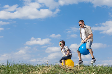 Image showing Father and son playing on the field at the day time.