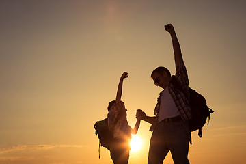 Image showing Father and son walking on the field at the sunset time.