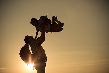 Image showing Father and son walking on the field at the sunset time.