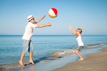 Image showing Father and daughter playing on the beach at the day time.