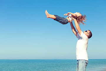 Image showing Father and son playing on the beach at the day time.