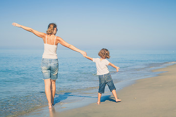 Image showing Mother and son playing on the beach at the day time.