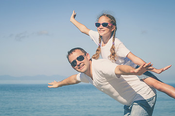 Image showing Father and daughter playing on the beach at the day time.