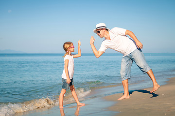 Image showing Father and daughter playing on the beach at the day time.