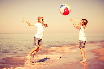 Image showing Two sisters playing on the beach at the day time.