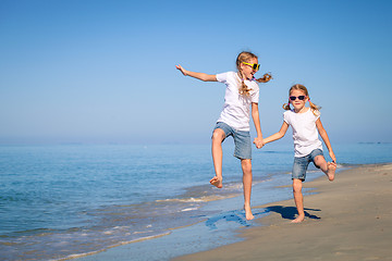 Image showing Two sisters playing on the beach at the day time.