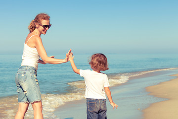 Image showing Mother and son playing on the beach at the day time.