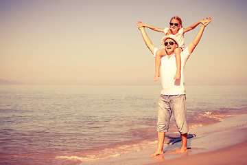 Image showing Father and daughter playing on the beach at the day time.