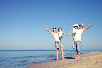 Image showing Happy family walking on the beach at the day time.