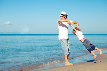 Image showing Father and son playing on the beach at the day time.