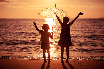 Image showing Happy children playing on the beach at the sunset time.
