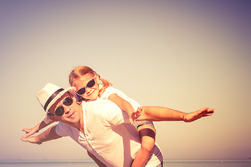 Image showing Father and daughter playing on the beach at the day time.