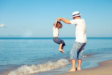 Image showing Father and son playing on the beach at the day time.