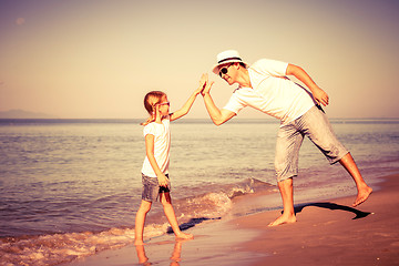 Image showing Father and daughter playing on the beach at the day time.