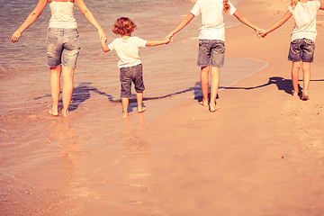 Image showing Mother and  children playing on the beach.