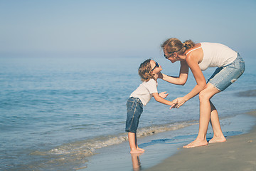 Image showing Mother and son playing on the beach at the day time.