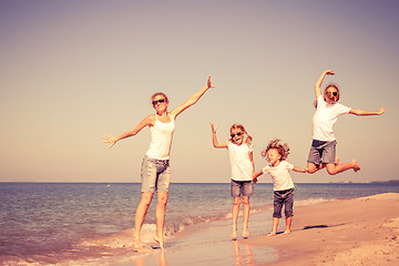 Image showing Mother and children playing on the beach at the day time.