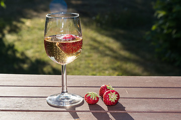 Image showing Backlit glass with sparkling wine and strawberries