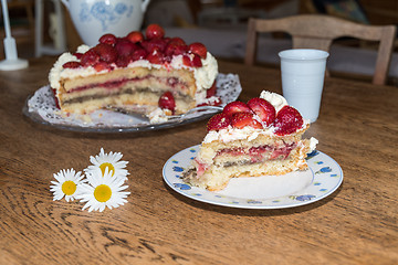 Image showing Cut piece of strawberry cake on a plate at a table