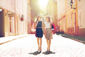 Image showing happy women with shopping bags walking in city