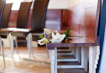 Image showing white lily on bench at funeral in church