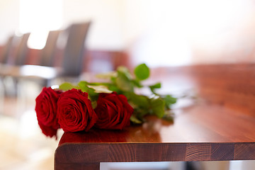 Image showing red roses on bench at funeral in church