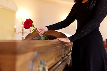 Image showing woman with red roses and coffin at funeral