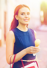Image showing woman with shopping bags and ice cream in city