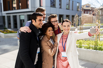 Image showing happy people with conference badges taking selfie