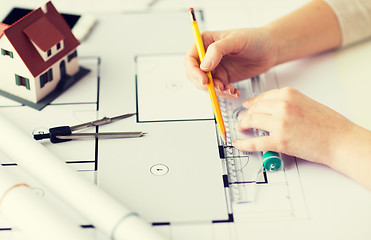 Image showing close up of hands with compass measuring blueprint