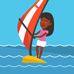 Image showing Young woman windsurfing in the sea.