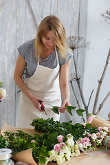 Image showing Young girl florist makes bouquet