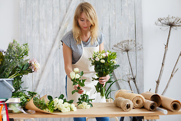 Image showing Young woman in flower shop