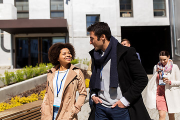 Image showing people with coffee and conference badges in city