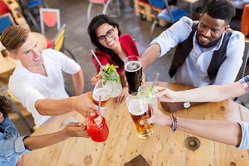 Image showing friends clinking glasses with drinks at restaurant