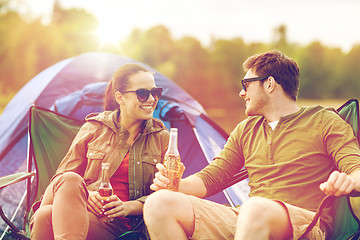 Image showing happy couple drinking beer at campsite tent