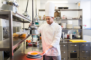 Image showing happy male chef cooking food at restaurant kitchen