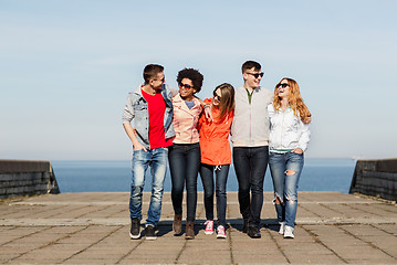 Image showing happy teenage friends in shades talking on street