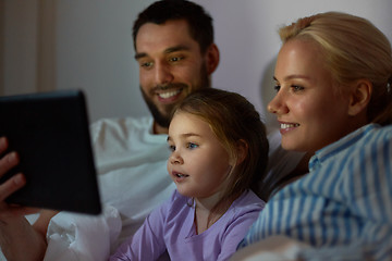 Image showing happy family with tablet pc in bed at home