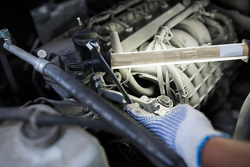 Image showing mechanic man with wrench repairing car at workshop