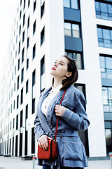 Image showing young pretty brunette business woman posing against modern building, lifestyle people concept