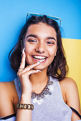 Image showing young cheerful indian mixed races girl happy smiling, posing on blue background in summer fashion clothers. lifestyle people concept