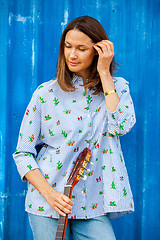 Image showing Portrait of a beautiful smiling woman with a guitar 