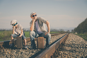 Image showing Father and son walking on the railway at the day time.