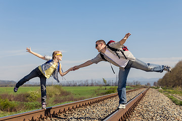 Image showing Father and daughter walking on the railway at the day time.