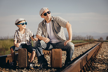 Image showing Father and son walking on the railway at the day time.