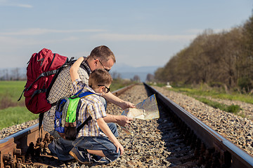 Image showing Father and son walking on the railway at the day time.